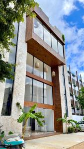 a building with large glass windows on the side of it at Chic 2BR Condo, Private Jacuzzi and 2 Free Bikes in Tulum