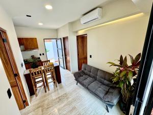 a living room with a couch and a table at Chic 2BR Condo, Private Jacuzzi and 2 Free Bikes in Tulum