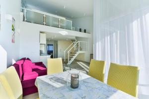 un soggiorno con tavolo e divano rosa di Apartments Laura 1 a Privlaka (Brevilacqua)