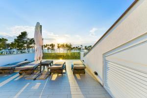 un patio con tavolo, sedie e ombrellone di Apartments Laura 1 a Privlaka (Brevilacqua)