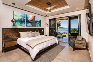 ポトレロにあるBeachfront Pool 5 BD Villaのベッドがあり海が見える寝室 +13枚の写真