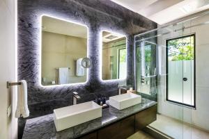 ポトレロにあるBeachfront Pool 5 BD Villaの洗面台が2つと大きな鏡があるバスルーム