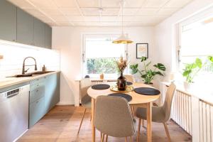 a kitchen and dining room with a table and chairs at Modernes Waldhaus im Spreewald in Lübben
