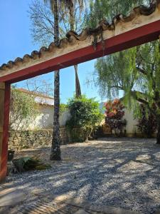 a red archway in a yard with trees at Pousada Padre Toledo in Tiradentes