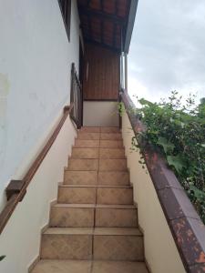 a staircase leading up to a house with a wooden door at Residência acolhedora amamos receber hospedes in Joinville +2 photos