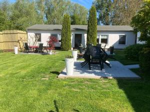 a yard with a house with a table and chairs at Ruegen_Fewo 102 in Sagard
