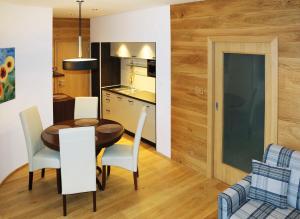 a kitchen and dining room with a table and chairs at PRIVILEGED LESNÁ - with Garden Terrace in Tatranská Lomnica