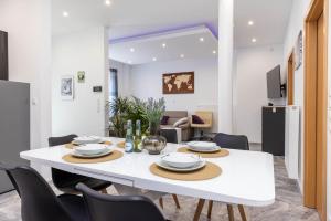 a dining room with a white table and chairs at Rheinland Apartments - Stilvolle, moderne Unterkunft mit kostenfreiem WLAN und Parkplatz in Andernach