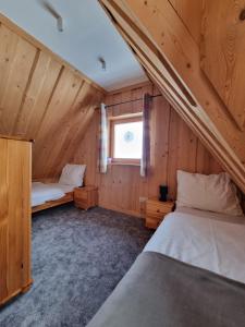een slaapkamer met 2 bedden in een houten hut bij Podhalańska Chatka Zakopane in Zakopane