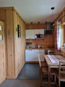 een keuken met houten wanden en een tafel en stoelen bij Podhalańska Chatka Zakopane in Zakopane