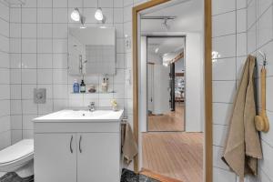 une salle de bain avec un lavabo, des toilettes et un miroir dans l'établissement Urban Architectural Retreat, à Tromsø 13 autres photos