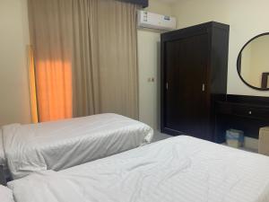 ein Hotelzimmer mit zwei Betten und einem Spiegel in der Unterkunft فيلا ريام السيف in Al Namas + 2 Fotos