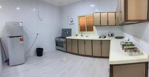 eine Küche mit Kühlschrank und Arbeitsplatte in der Unterkunft فيلا ريام السيف in Al Namas