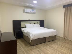 ein Schlafzimmer mit einem großen Bett mit weißer Bettwäsche in der Unterkunft فيلا ريام السيف in Al Namas
