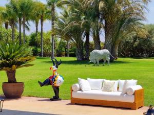 a couch and a statue of a cow in a park at Villa Alcázar Marrakech in Had Abdallah Rhiat +44 photos