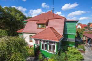 a green and white house with a red roof at Pokoje Gościnne u Markusa in Polanica-Zdrój