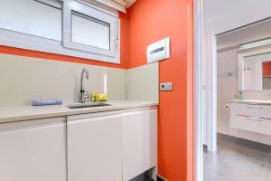 a kitchen with an orange wall and a sink at Vistas 180º, al mar, puesta de sol, Free Wifi-parking in Bakio +25 photos