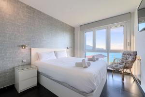 a bedroom with a large white bed and a window at Vistas 180º, al mar, puesta de sol, Free Wifi-parking in Bakio