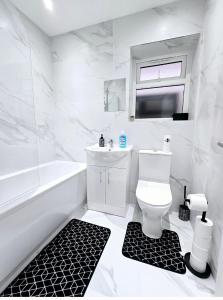 a white bathroom with a sink and a toilet at The Wembley Park Apartment in London +23 photos