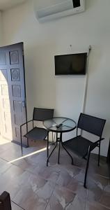 a room with two chairs and a table and a tv at Suites Praiamar Vista Linda Bertioga in Bertioga +37 photos