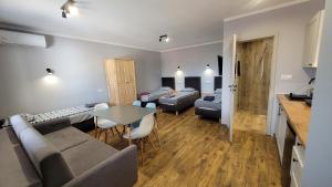 a living room with a couch and a table and chairs at Wrzosowe Wzgórze 5 - Apartamenty in Chęciny