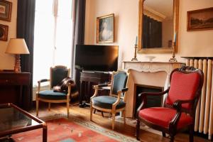 ein Wohnzimmer mit einem Klavier, Stühlen und einem Spiegel in der Unterkunft Spacious & Quiet Flat, Close to Paris Expo in Vanves