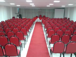 um quarto vazio com cadeiras vermelhas e tapete vermelho em Parati Palace Hotel em Santo Antônio de Jesus