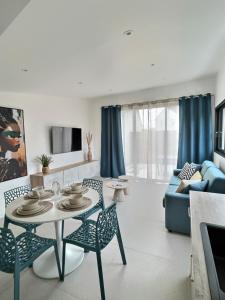 Una sala de estar con una mesa y sillas y un sofá. en Le Baule D'air, en La Baule