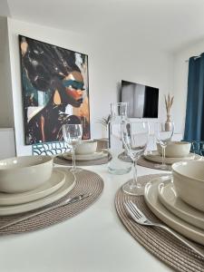 a dining room table with plates and glasses on it at Le Baule D'air in La Baule +7 photos