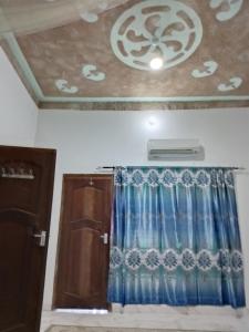 a room with a ceiling with a curtain and a window at Precious Bungalow House in Lamu +2 photos