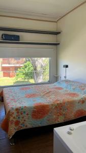 a bedroom with a large bed with a window at Las Marinas Playa Grande 1 in Piriápolis +17 photos