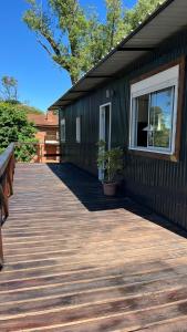 a wooden deck next to a building with a window at Las Marinas Playa Grande 1 in Piriápolis