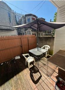 a patio with an umbrella and a table and chairs at Camila In in Philadelphia