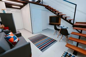 a living room with a staircase and a tv at Mini Loft Siena in Sinop