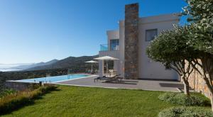 a villa with a view of a swimming pool at Elounda Luxury Villas in Elounda