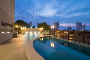 a swimming pool on the roof of a building at night at Hotel Gran Odara in Cuiabá