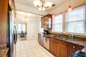 a kitchen with wooden cabinets and a sink at Walk to The Grandin Theatre Roanoke Unit with Yard! in Roanoke +16 photos