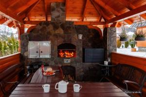 a patio with a stone fireplace in a house at TYLICZ W DECHĘ Pokoje i Apartamenty in Tylicz