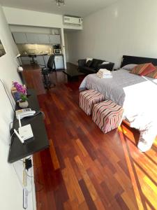 Un dormitorio con una cama y suelo de madera. en Nice studio at Nicaragua 6042, en Buenos Aires 18 fotos más