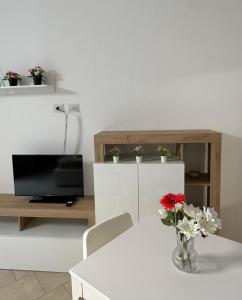 a living room with a white table with a vase of flowers at Sole e Mare in Catania