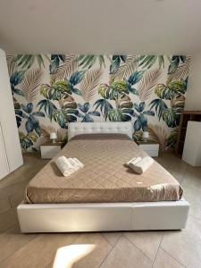 a bedroom with a bed with a tropical wallpaper at Sole e Mare in Catania