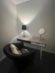 a room with a desk with a chair and a table with a lamp at Princes Street Executive Apartment 1 in Thurso