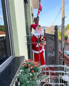 Eine Statue eines Weihnachtsmanns, der auf einem Balkon steht in der Unterkunft Pouso das Flores - Próximo a Maria Fumaça in Tiradentes + 98 Fotos