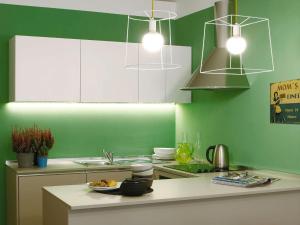 a kitchen with green walls and a white counter top at Le Tre Madame in Turin