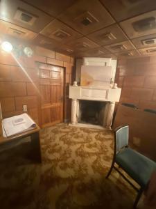 a room with a fireplace and a chair in it at Gogol House in Kutaisi