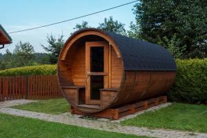 a small wooden hobbit house with a black roof at Domki Krótki Szpic in Istebna