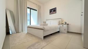 a white bedroom with a bed and a window at Sleek 1BR in DSO, Dubai in Dubai +28 photos