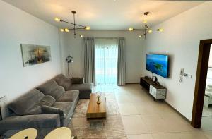 a living room with a couch and a table at Sleek 1BR in DSO, Dubai in Dubai
