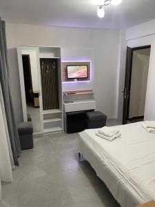 een slaapkamer met een bed en een flatscreen-tv bij Pensiunea White House in Straja