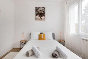 a bedroom with a white bed with towels on it at Elégant Flat Paris CDG Expo in Aulnay-sous-Bois